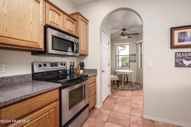 kitchen featuring light tile patterned floors, stainless steel appliances, and ceiling fan