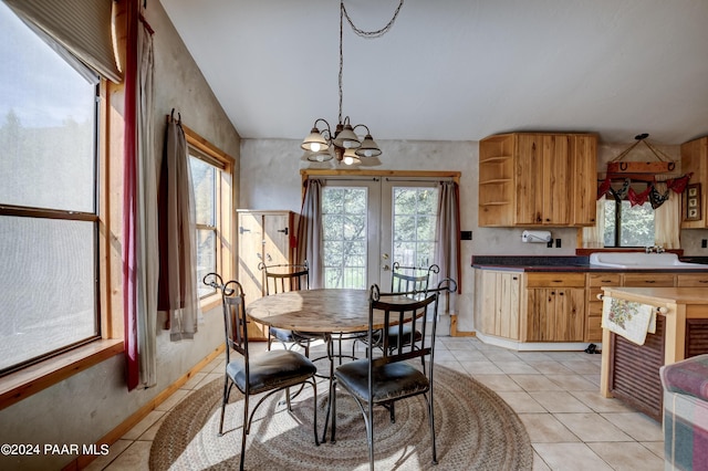 tiled dining space featuring french doors, sink, and a chandelier