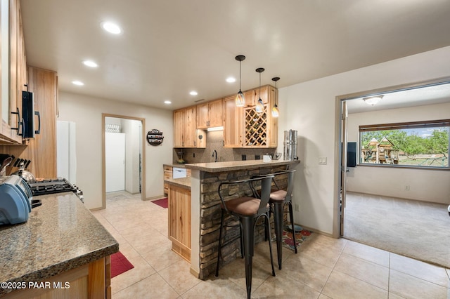 1501 W Kelly Dr, Prescott, AZ 86305 - kitchen with recessed lighting, a kitchen bar, a peninsula, tasteful backsplash, and light colored carpet