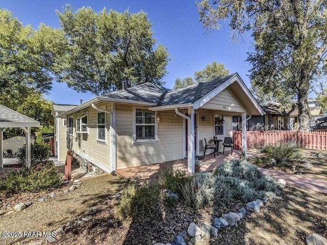 view of front of property with fence and a patio area