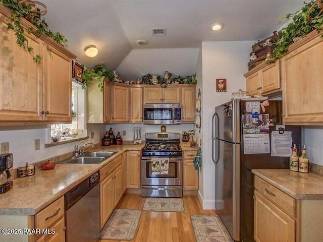 kitchen with light brown cabinets, visible vents, a sink, light wood-style floors, and appliances with stainless steel finishes