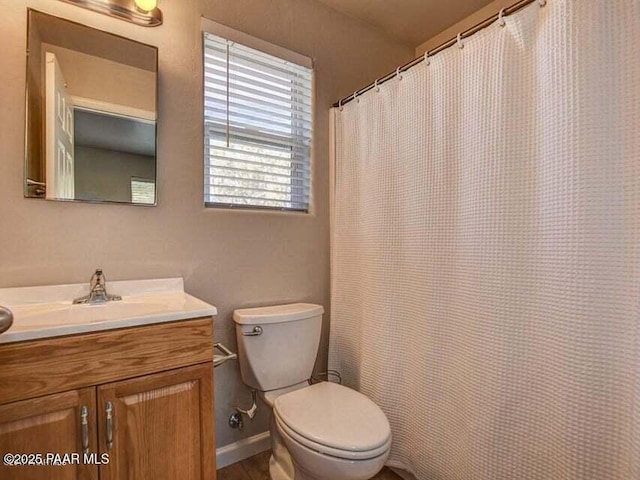 bathroom featuring a shower with curtain, baseboards, toilet, and vanity