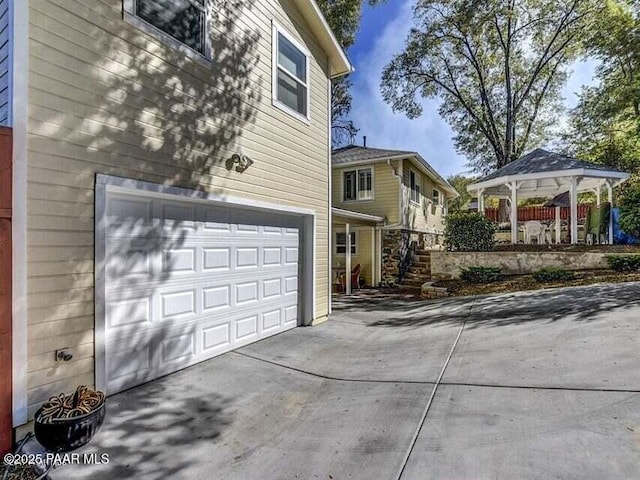 view of side of home featuring a garage and concrete driveway