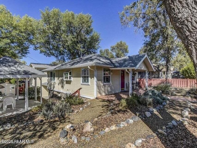 view of front of property with a patio and fence