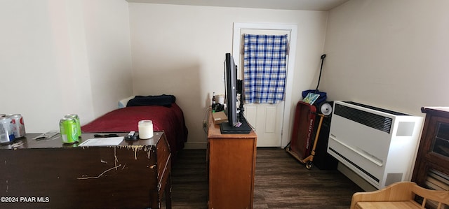 bedroom featuring heating unit and dark hardwood / wood-style floors