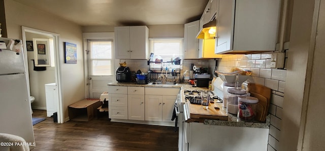 kitchen featuring tasteful backsplash, white fridge, white cabinetry, and dark hardwood / wood-style floors