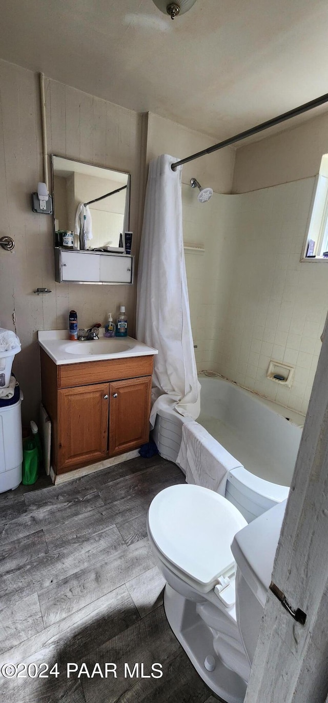 full bathroom featuring hardwood / wood-style floors, vanity, toilet, and shower / tub combo