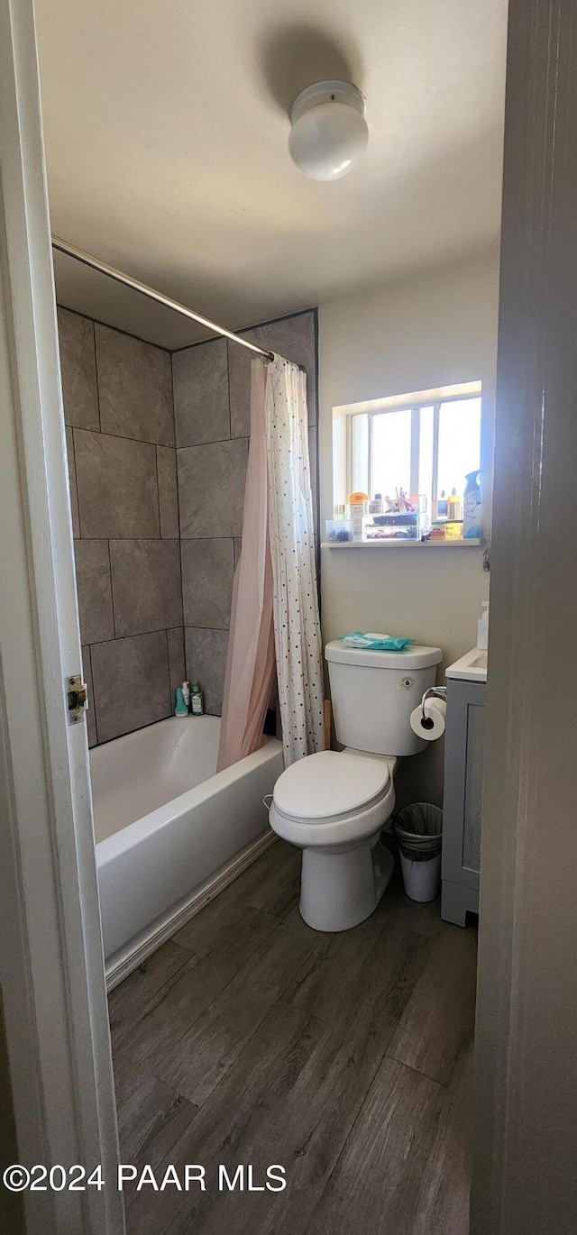 full bathroom with vanity, toilet, shower / bath combo with shower curtain, washer / dryer, and wood-type flooring