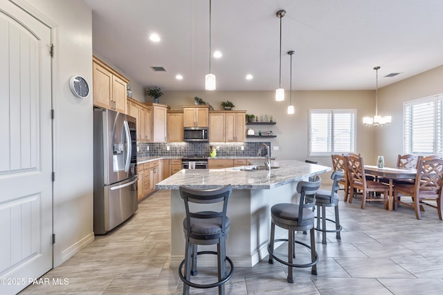 kitchen featuring a sink, tasteful backsplash, stainless steel appliances, light brown cabinets, and visible vents