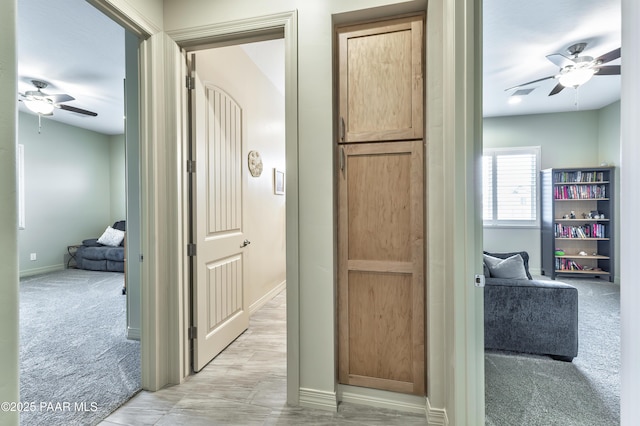 corridor with light carpet and baseboards