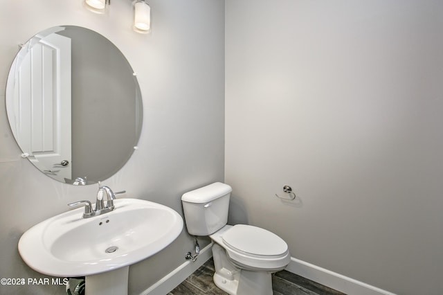 bathroom with toilet, sink, and hardwood / wood-style floors