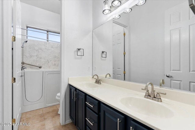 bathroom with a washtub, a sink, toilet, and tile patterned floors