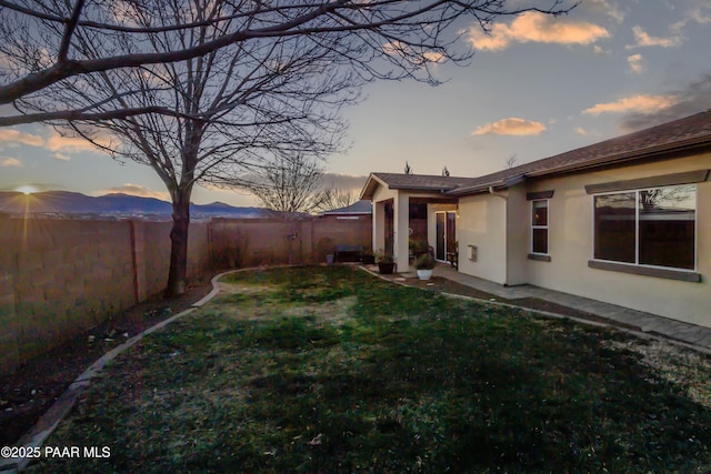 yard at dusk featuring a mountain view