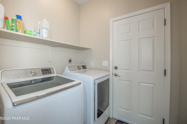 clothes washing area featuring washer and clothes dryer