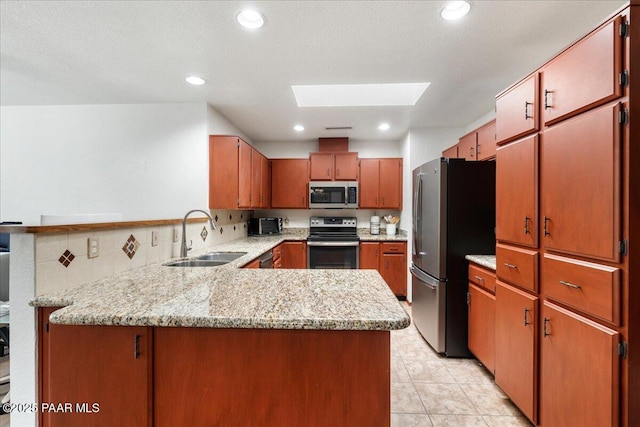 4860 N Treasure Cir, Prescott Valley, AZ 86314 - kitchen featuring stainless steel appliances, a sink, a skylight, a peninsula, and light tile patterned flooring