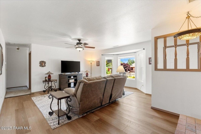 4860 N Treasure Cir, Prescott Valley, AZ 86314 - living room featuring a ceiling fan, wood finished floors, attic access, baseboards, and a textured ceiling