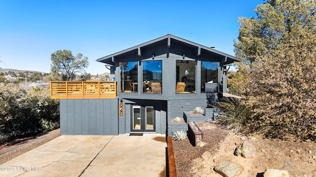 view of front facade featuring french doors, a patio, and a deck