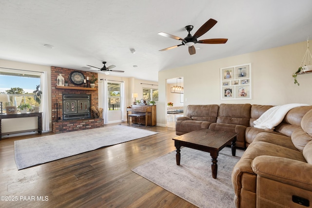 living room with hardwood / wood-style flooring, ceiling fan, and a wood stove