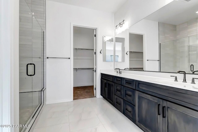 bathroom featuring a shower with door and vanity