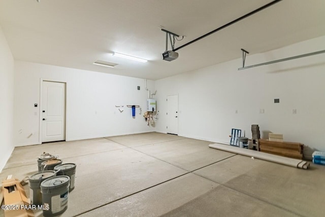 garage featuring a garage door opener and water heater