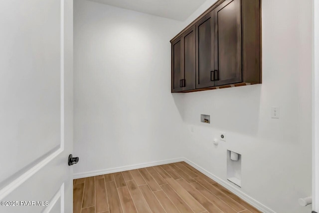 washroom featuring gas dryer hookup, cabinets, hookup for a washing machine, hookup for an electric dryer, and light hardwood / wood-style flooring