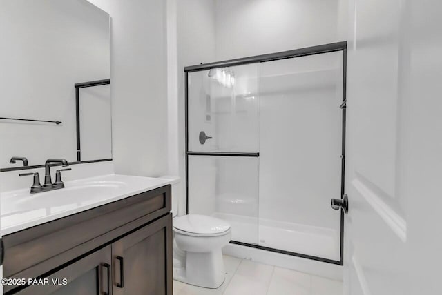 bathroom featuring walk in shower, vanity, toilet, and tile patterned flooring