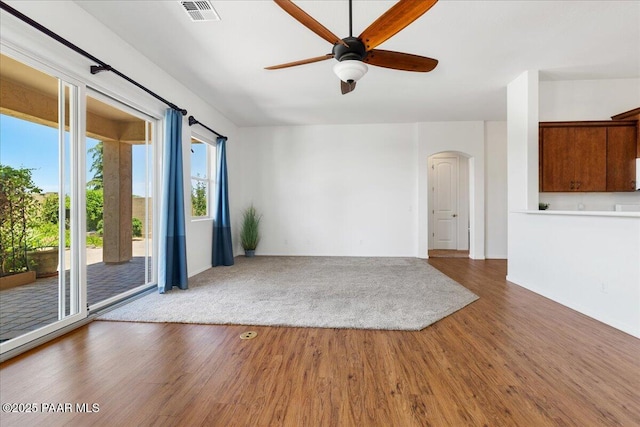 5510 N Foster Pl, Prescott Valley, AZ 86314 - unfurnished living room with arched walkways, wood finished floors, and a ceiling fan