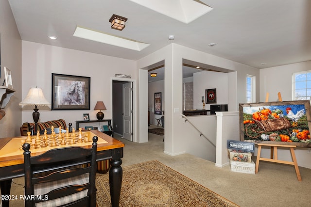 carpeted dining space featuring a skylight