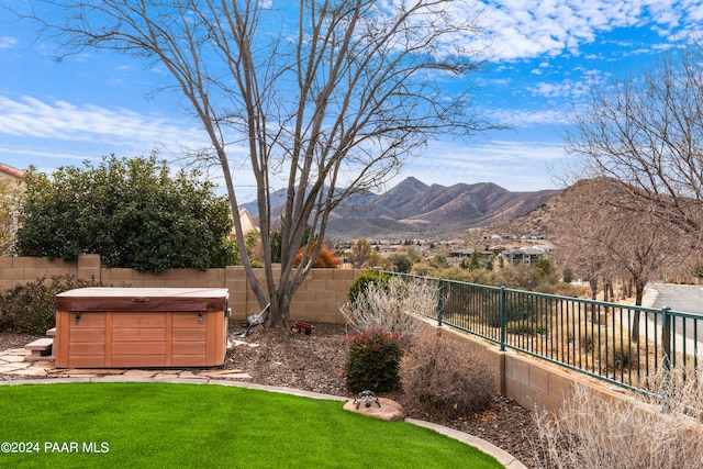 view of yard with a mountain view and a hot tub