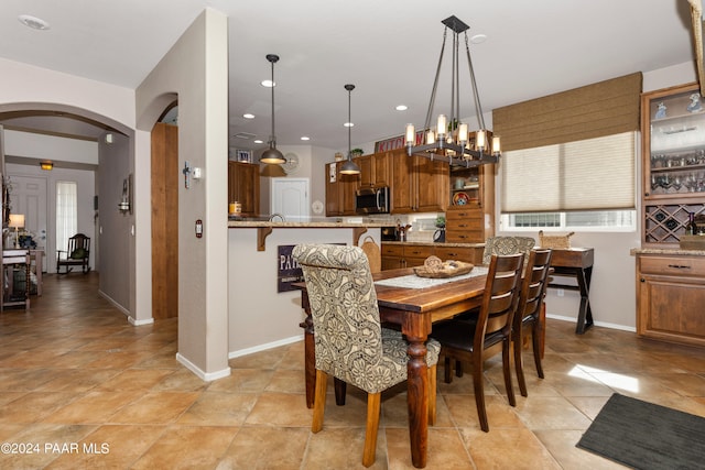 dining area featuring a notable chandelier and light tile patterned flooring