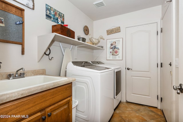 laundry area featuring washer and clothes dryer, sink, and cabinets