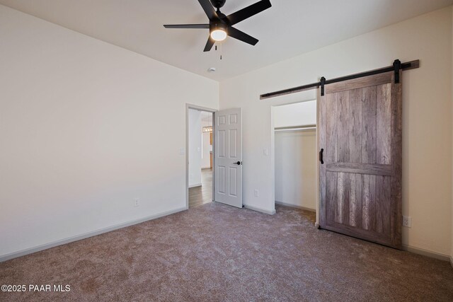 13555 E Soleil Down Rd, Mayer, AZ 86333 - unfurnished bedroom featuring carpet flooring, a barn door, ceiling fan, and a closet