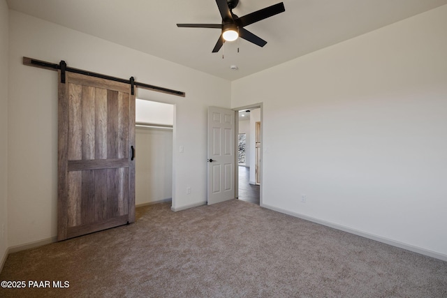13555 E Soleil Down Rd, Mayer, AZ 86333 - unfurnished bedroom featuring a barn door, carpet flooring, a closet, and a ceiling fan