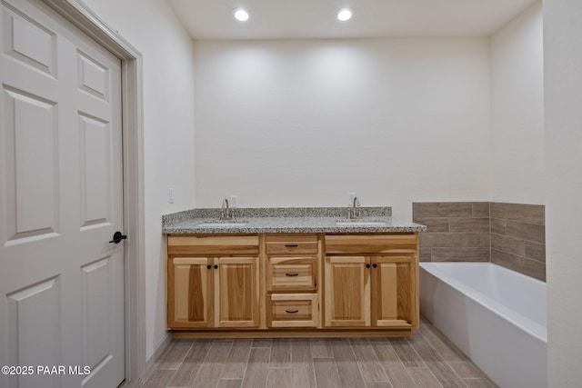 13555 E Soleil Down Rd, Mayer, AZ 86333 - bathroom featuring a garden tub, double vanity, wood finished floors, and recessed lighting