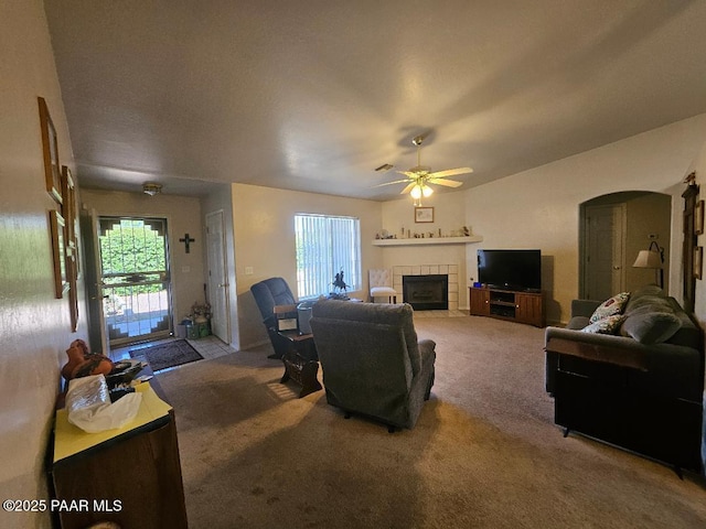 4825 E Sauter Dr, Prescott Valley, AZ 86314 - living room with arched walkways, a fireplace, carpet, and ceiling fan
