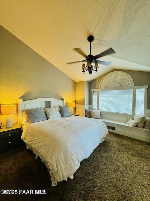 bedroom with lofted ceiling, carpet, visible vents, and a textured ceiling