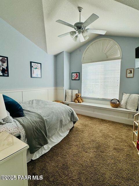 carpeted bedroom with lofted ceiling, ceiling fan, and a textured ceiling