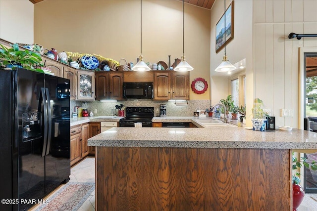 10875 E Manzanita Trl, Dewey-Humboldt, AZ 86327 - kitchen with black appliances, a sink, a peninsula, tasteful backsplash, and hanging light fixtures