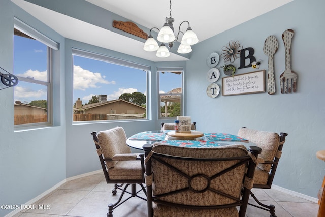 dining room featuring a chandelier, light tile patterned flooring, and baseboards