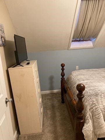 bedroom with lofted ceiling and dark carpet