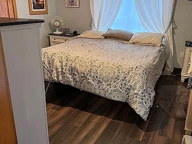 bedroom with dark hardwood / wood-style flooring