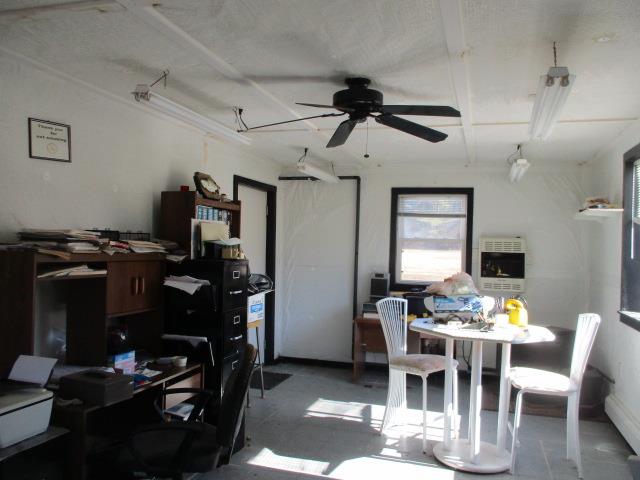 dining room with ceiling fan, concrete floors, and heating unit