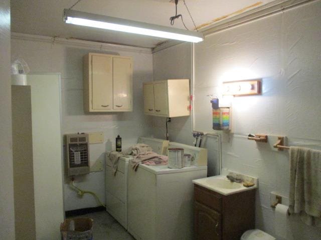 washroom featuring independent washer and dryer, heating unit, and sink