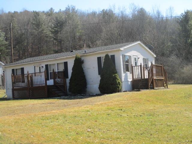 view of front of house featuring a front yard and a wooden deck