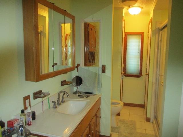 bathroom with tile patterned flooring, an enclosed shower, toilet, vanity, and ornamental molding