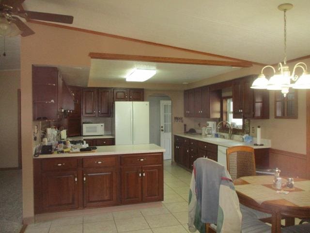 kitchen featuring sink, hanging light fixtures, vaulted ceiling, white appliances, and light tile patterned flooring