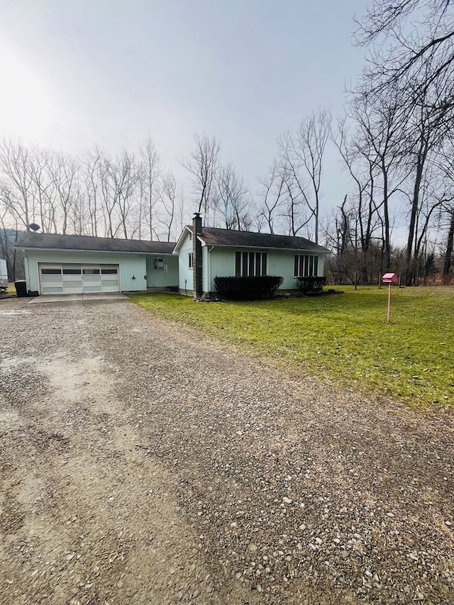 ranch-style house featuring a garage and a front yard