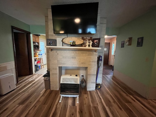 interior details featuring a fireplace, hardwood / wood-style flooring, and heating unit