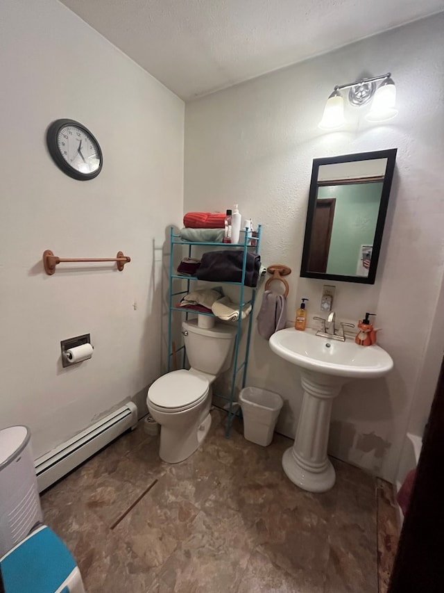 bathroom with toilet, a textured ceiling, and a baseboard radiator