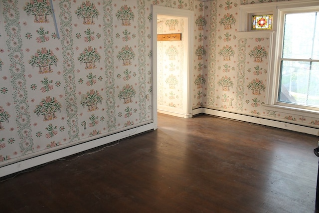 unfurnished room featuring dark hardwood / wood-style flooring and a baseboard radiator